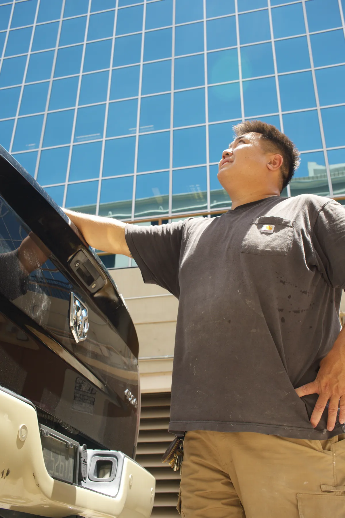 The owner of Luong Tile standing by his work truck at a commercial job site